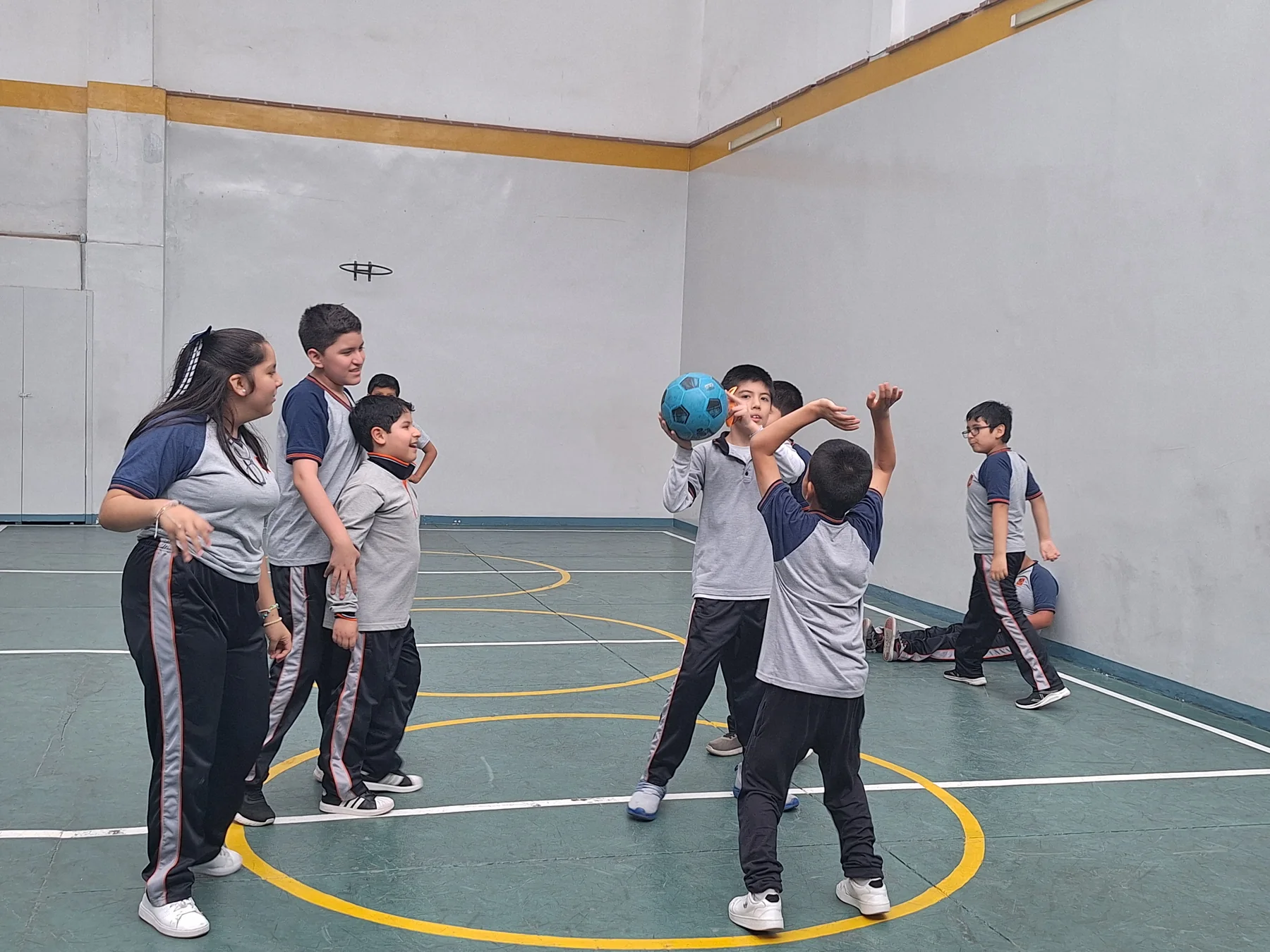 Estudiantes jugando con una pelota en el patio deportivo