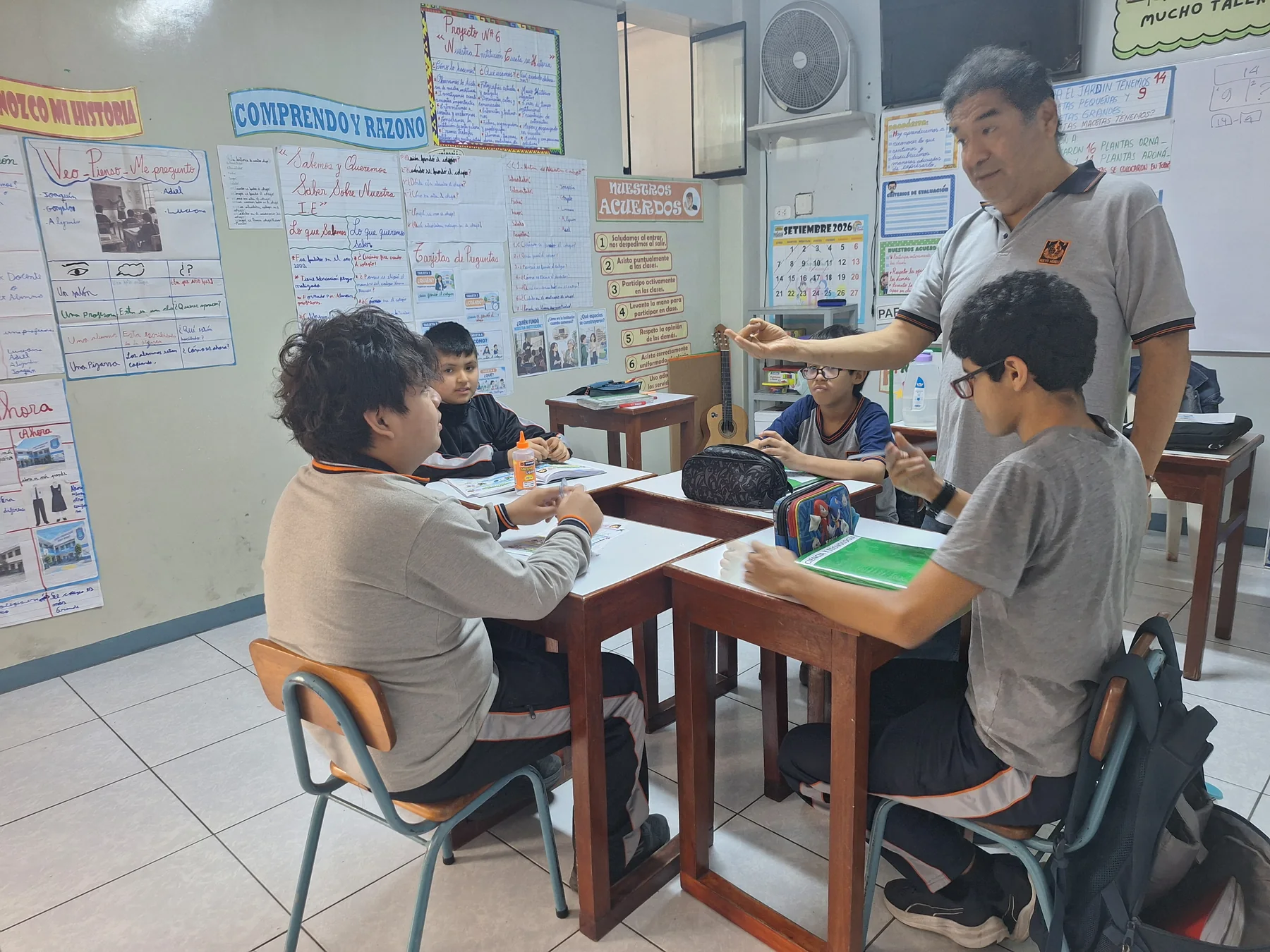 Docente guiando una actividad con material de trabajo en el aula